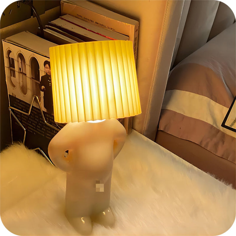 Dekorativ bordlampe med figurformet fod og plisseret cylinderskærm