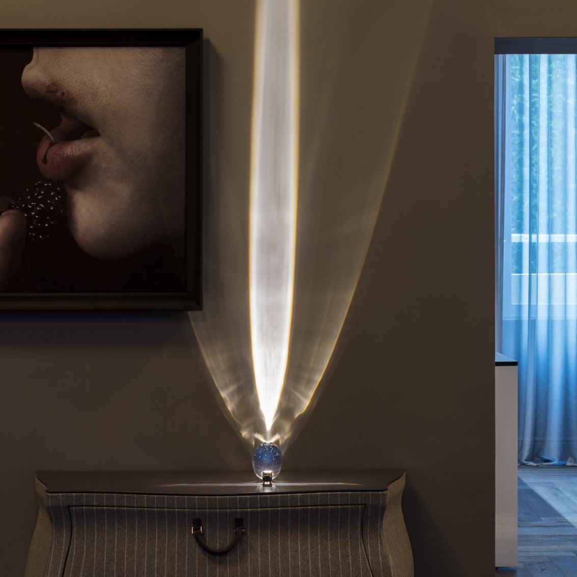 Oval dekorativ bordlampe med transparent linseformet krop og indvendig glød