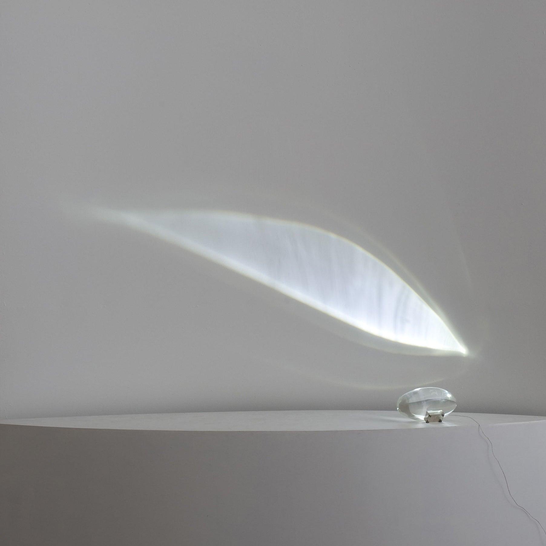 Oval dekorativ bordlampe med transparent linseformet krop og indvendig glød