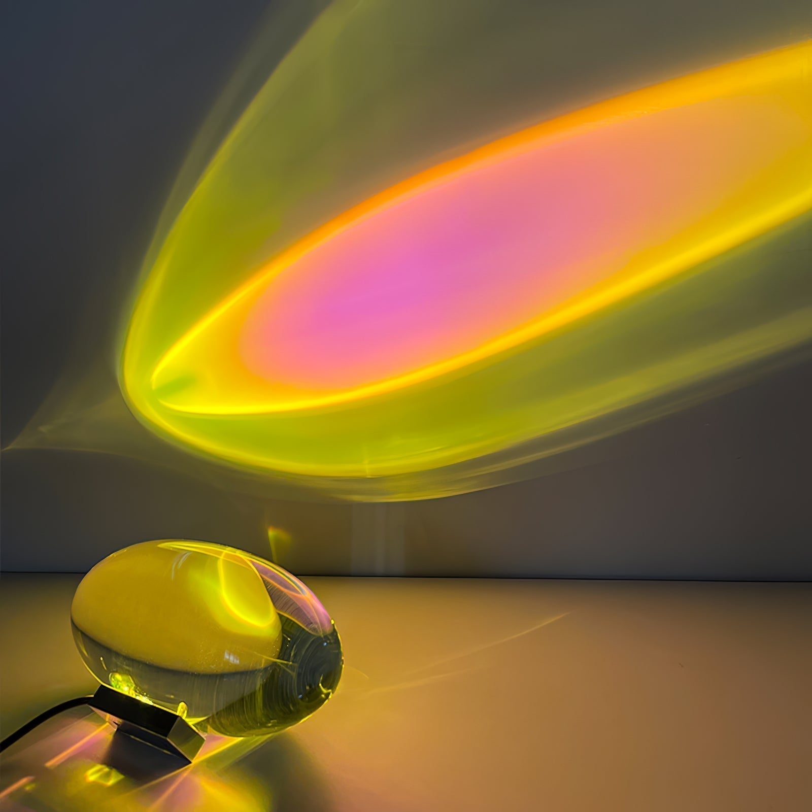 Oval dekorativ bordlampe med transparent linseformet krop og indvendig glød