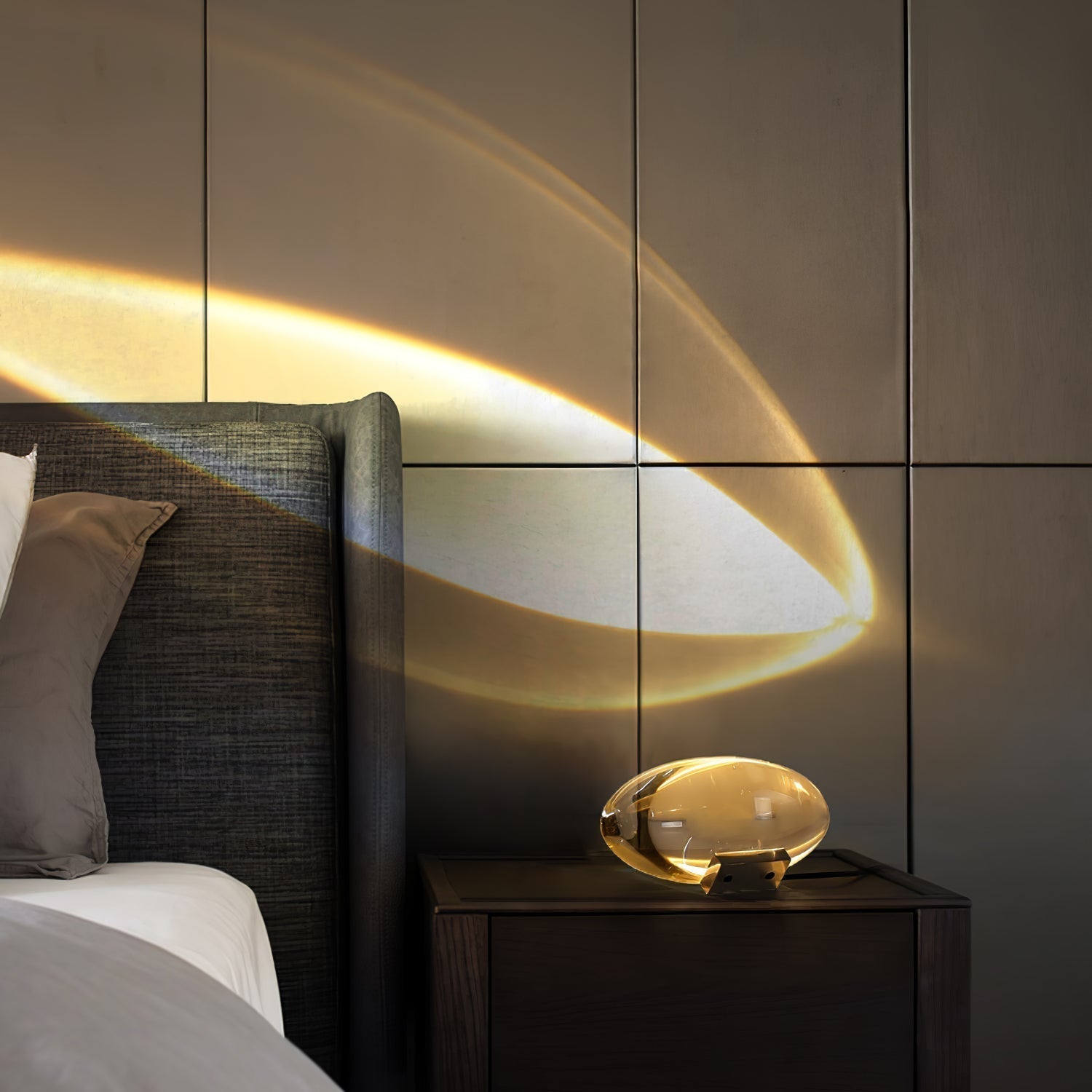Oval dekorativ bordlampe med transparent linseformet krop og indvendig glød