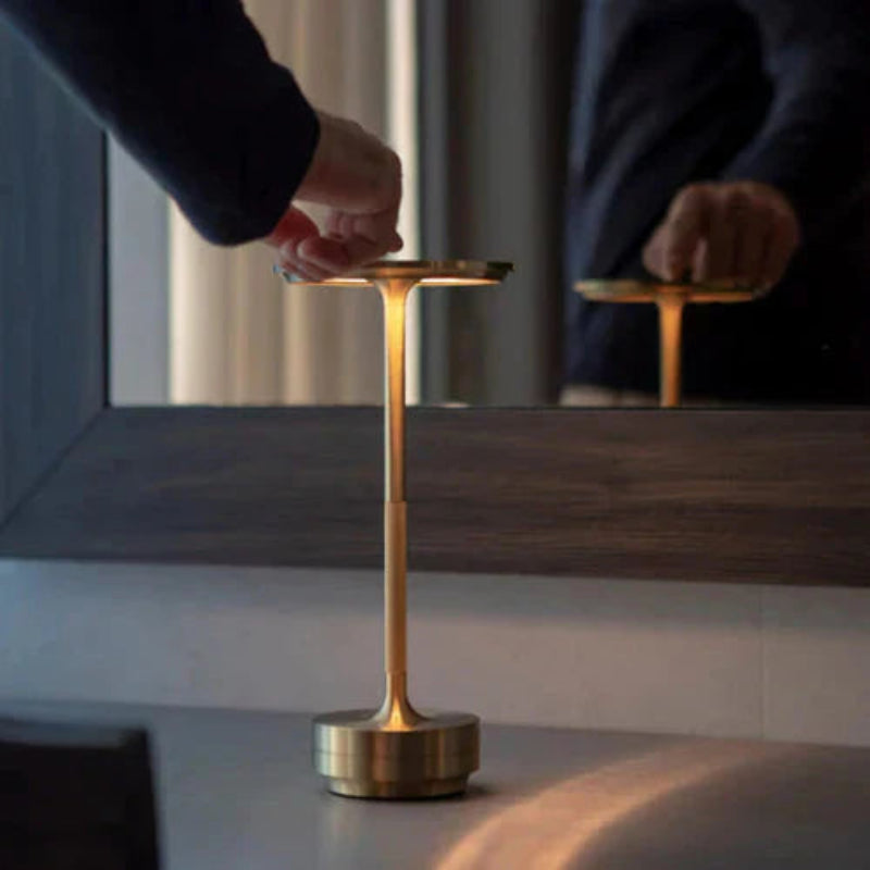 Skive bordlampe i messingdesign med flad skiveformet top og nedadvendt lyseffekt