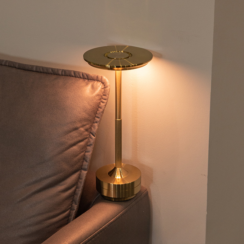 Skive bordlampe i messingdesign med flad skiveformet top og nedadvendt lyseffekt