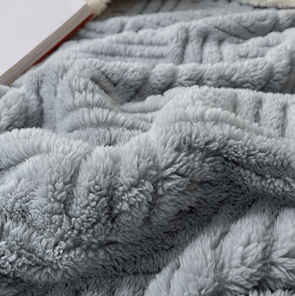 Reversible sofa blanket with embossed pattern and sherpa lining