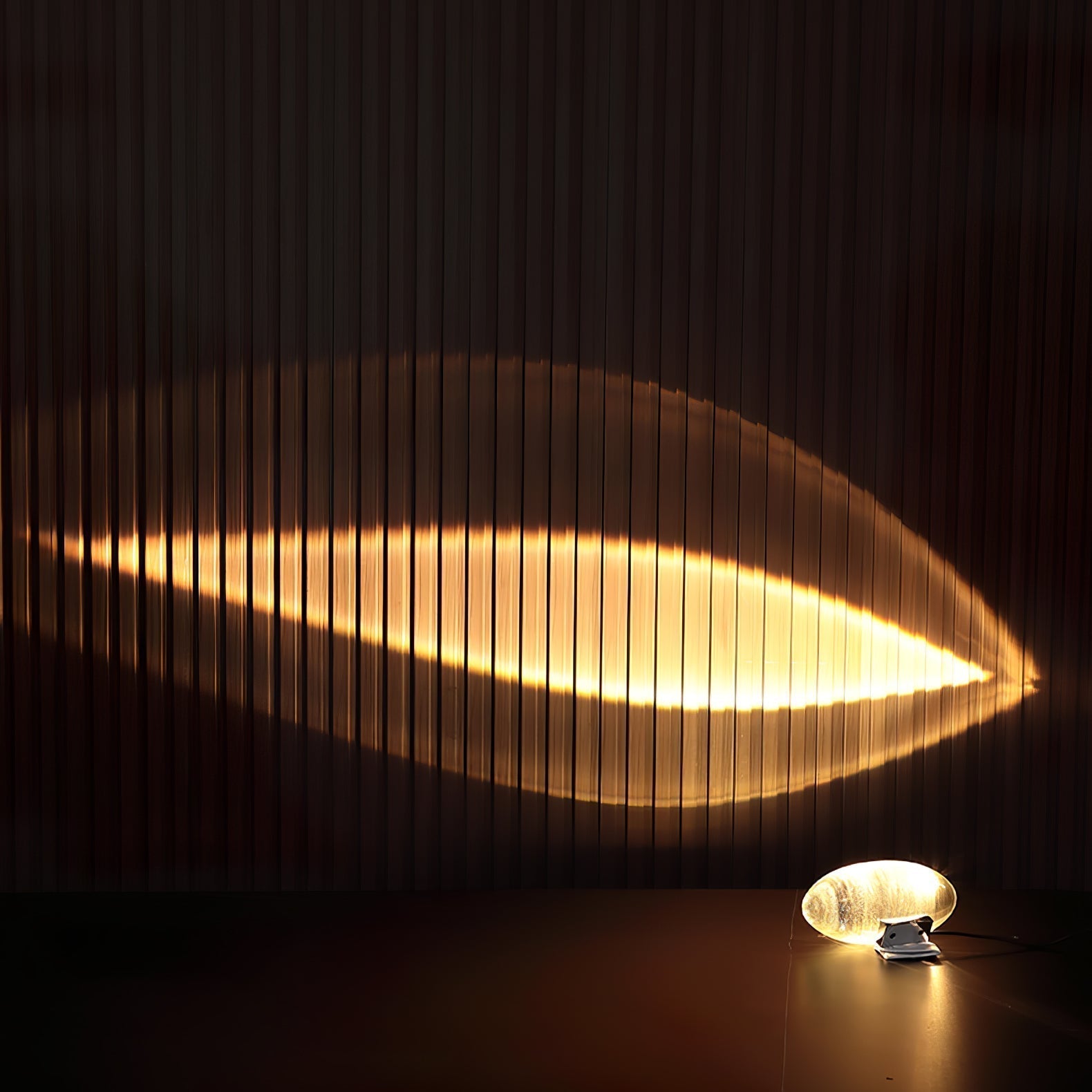 Oval dekorativ bordlampe med transparent linseformet krop og indvendig glød