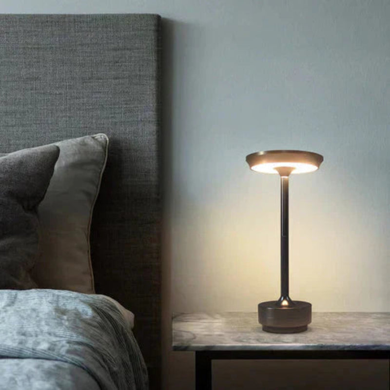 Skive bordlampe i messingdesign med flad skiveformet top og nedadvendt lyseffekt