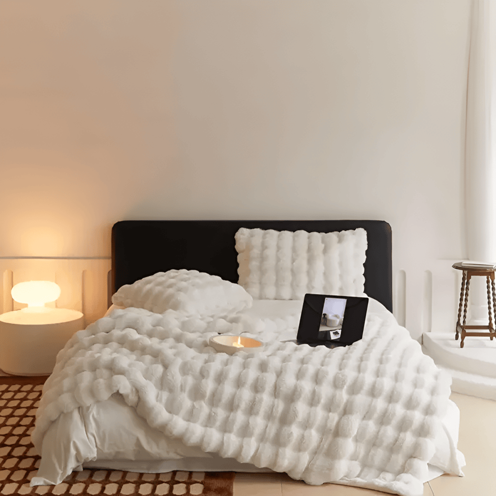 Sofatæppe i kunstpels med puffet quiltet struktur